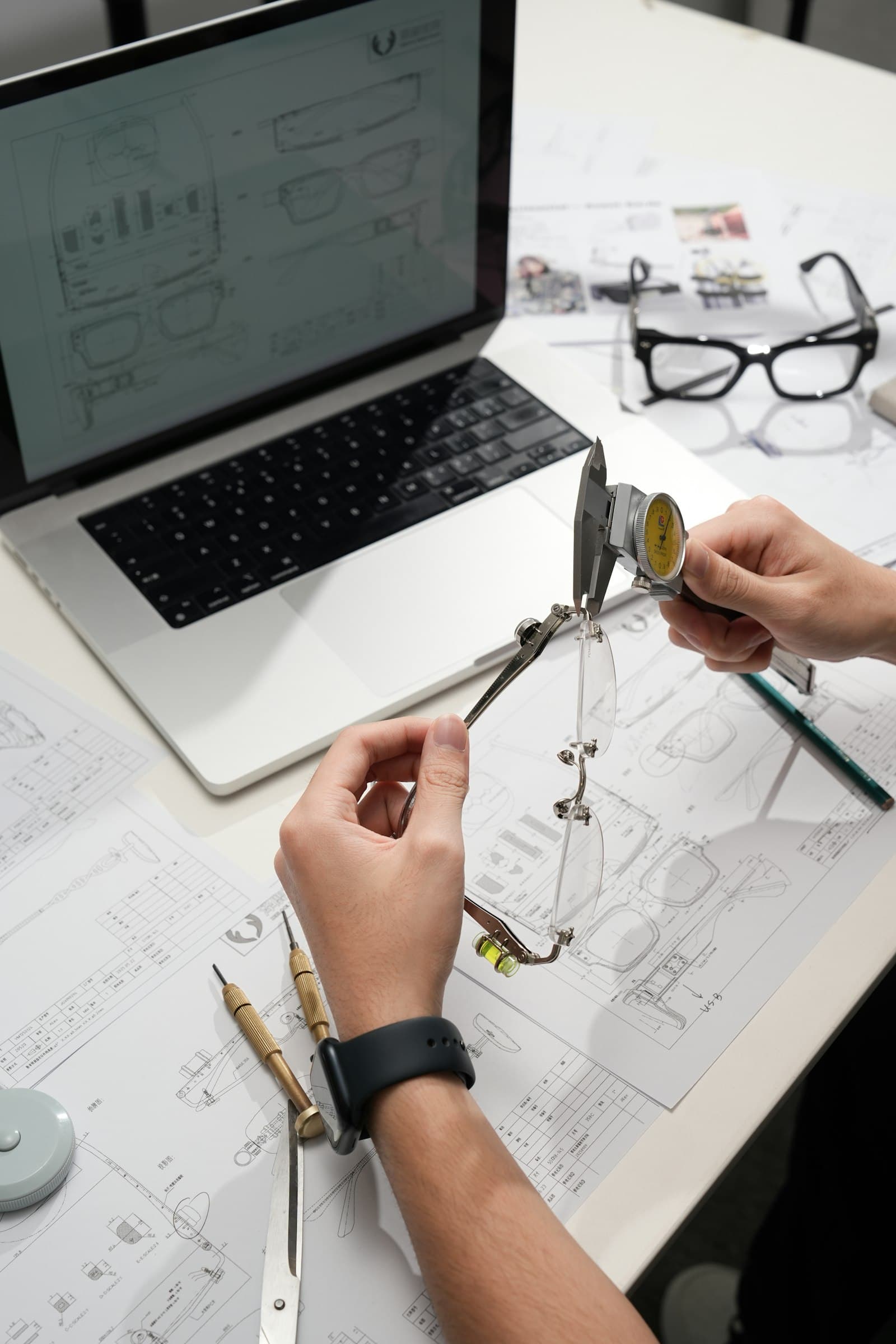 Mains mesurant une monture avec un instrument de précision